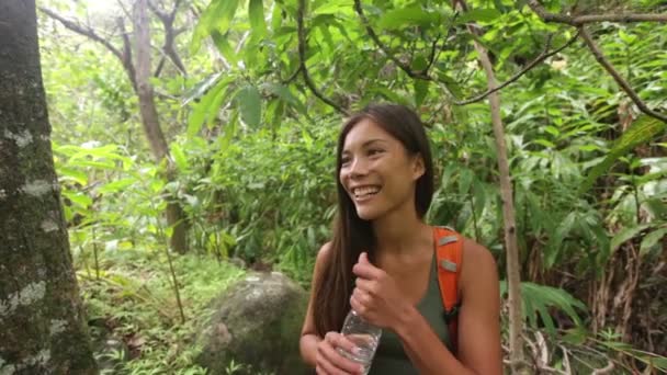 Wandelaars lopen in het regenwoud drinkwater — Stockvideo