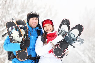 Winter couple outdoors on snowshoes clipart
