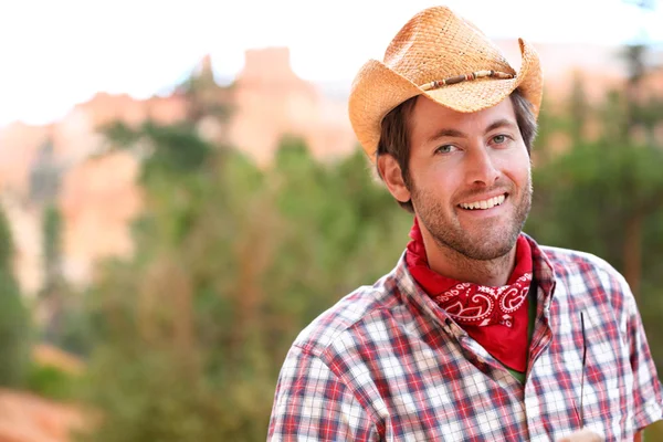 Cowboy-Mann lächelt glücklich mit Hut auf dem Land — Stockfoto