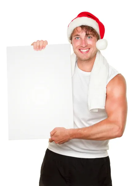 Fitness man holding sign wearing christmas santa hat — Stock Photo, Image