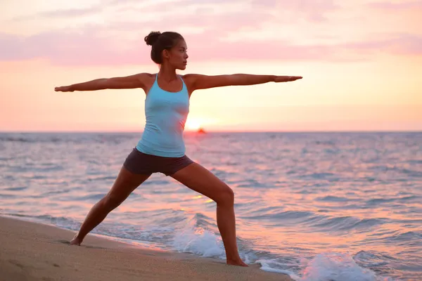 Mujer Yoga meditando en pose guerrera en la playa — Foto de Stock