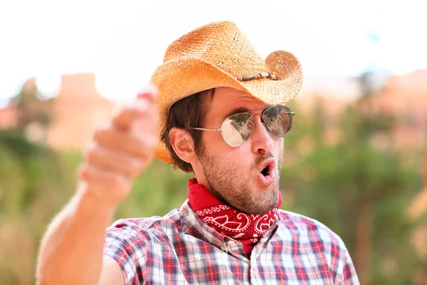 Cowboy man med solglasögon och hatt pekar — Stockfoto