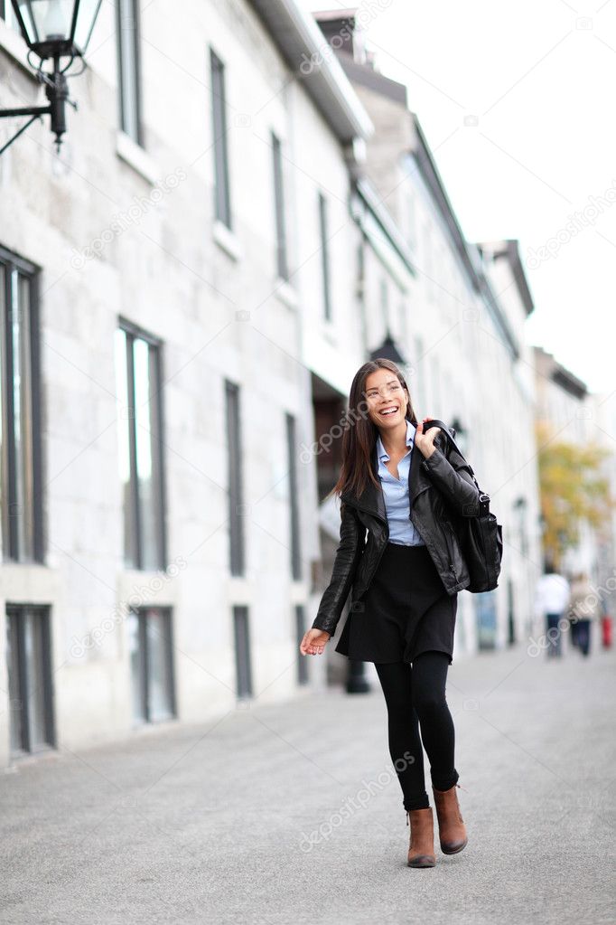 Mujer joven caminando en la calle de la ciudad, estilo de vida de otoño con  ropa de moda. Mujer profesional urbana en chaqueta de cuero negro,  leggings, falda Fotografía de stock 