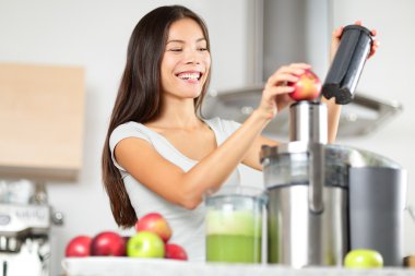 Juicing - woman making apple and vegetable juice clipart