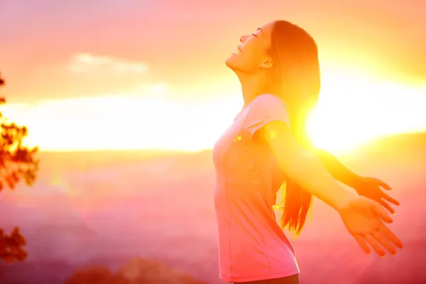 Безкоштовно щаслива жінка насолоджується природою захід сонця — стокове фото