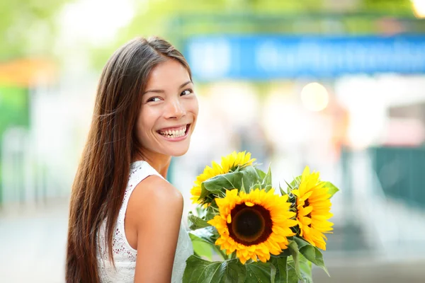 Mujer sosteniendo girasol sonriendo feliz —  Fotos de Stock