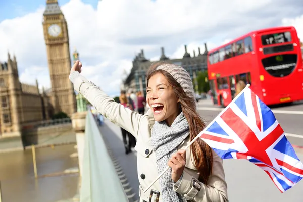 London - happy tourist holding UK flag by Big Ben Stock Photo