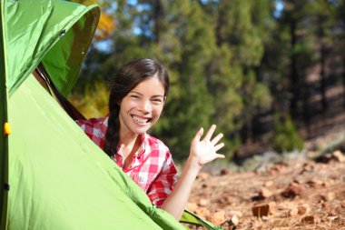 Camping woman waving hello from tent clipart