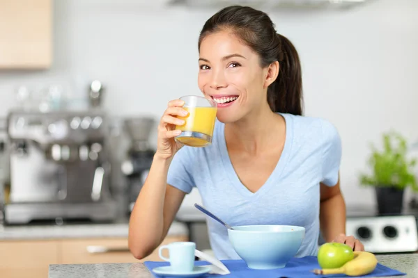 Chica bebiendo jugo de naranja desayunando — Foto de Stock