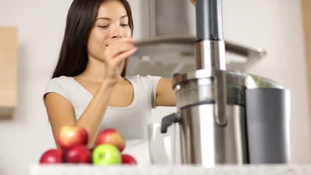 Mulher fazendo suco de maçã e legumes no espremedor — Vídeo de Stock