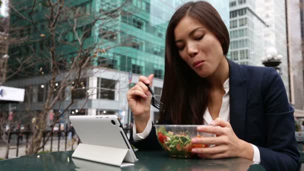 Kobieta przy użyciu komputera typu tablet jedzenie sałatka — Wideo stockowe