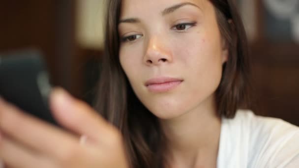 Frau nutzt App auf Smartphone im Café — Stockvideo