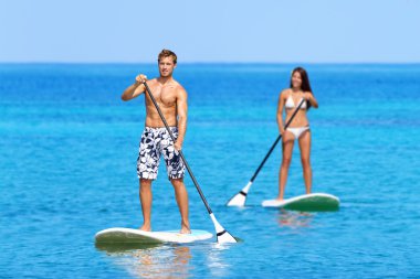 Paddleboard beach people on stand up paddle board clipart