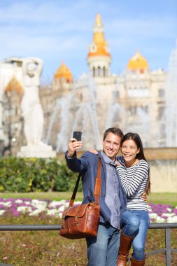 Tourist travel couple taking selfie in Barcelona clipart