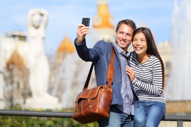 Happy urban city couple on travel in Barcelona clipart