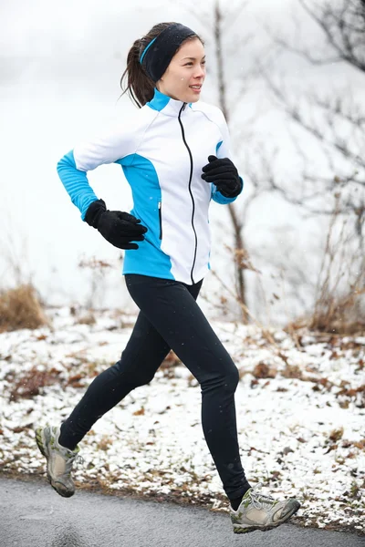 Mulher correndo em uma paisagem nevada — Fotografia de Stock