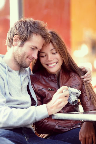 Feliz jovem casal olhando para fotos na câmera — Fotografia de Stock