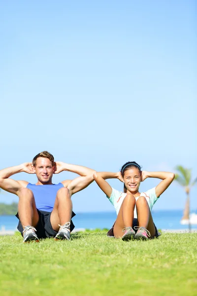 People exercising - Couple doing sit ups outdoors — Stock Photo, Image