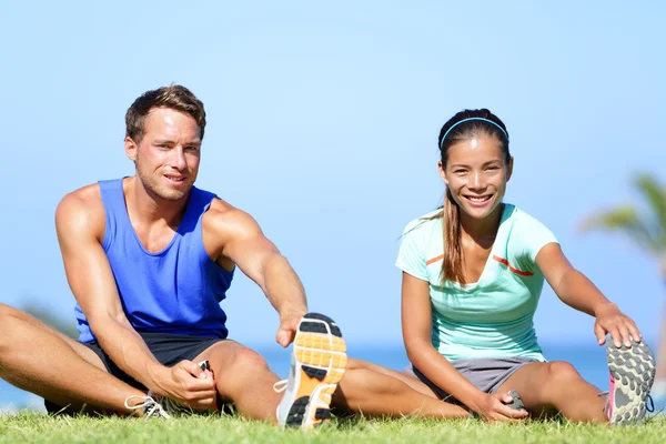 Exercícios de alongamento - Casal de fitness fora — Fotografia de Stock