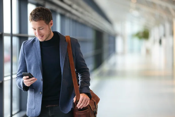 Uomo su smart phone - uomo d'affari in aeroporto Immagine Stock