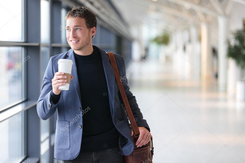 Businessman drinking coffee walking in airport Stock Photo by ©Maridav