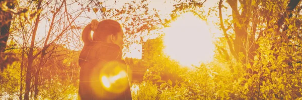 Mujer de otoño en hermosa naturaleza de destello de sol amarillo otoño con hojas que caen sobre el fondo del bosque. Retrato de encabezado de pancarta panorámica. — Foto de Stock