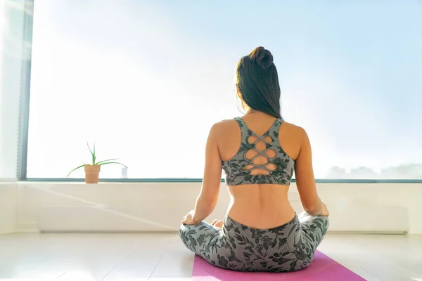 Joga w domu kobieta medytująca na macie w porannym słońcu. Medytacja jogi zdrowe życie — Zdjęcie stockowe