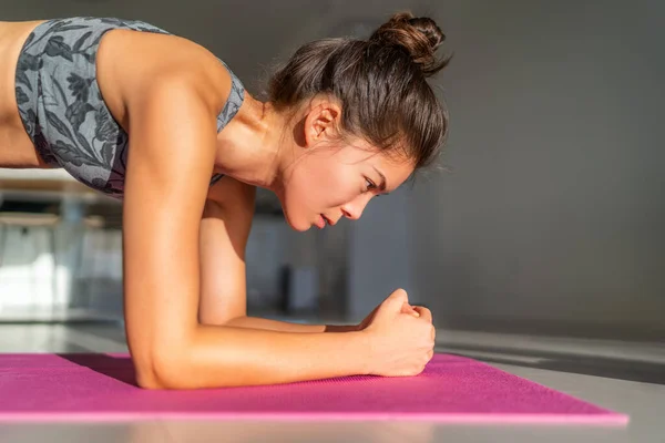 Accueil fitness, séance d'entraînement à la maison fille formation à l'intérieur des exercices de plancher sur tapis d'exercice en appartement condo. Femme asiatique planche faisant du yoga de poids corporel. Corps central — Photo