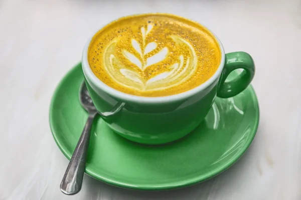 Tasse à café ayurvédique au curcuma latte. Boue de lait doré avec poudre de curcuma colorant anti-inflammatoire désintoxication alimentaire — Photo