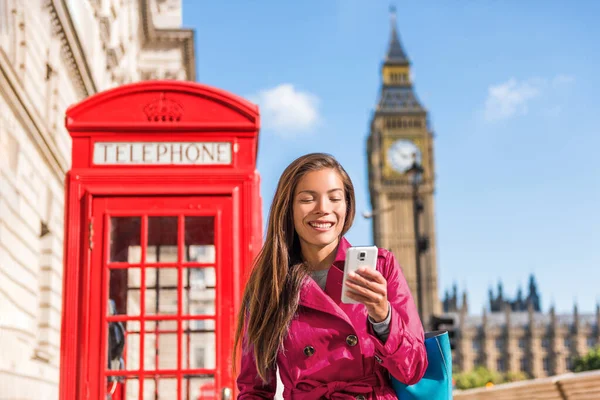 Londres mulher de negócios de telefone celular andando na cidade em casaco de trincheira rosa elegante, estilo de vida urbano. Cabine telefónica vermelha e fundo Big Ben Londres, Inglaterra, Reino Unido. Europa viagens. — Fotografia de Stock