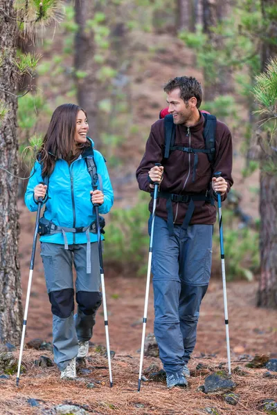 Glada par vandrare talar tillsammans på utomhus naturpromenad. Unga människor med flera raser vandrar utomhus i skogen. Leende asiatisk kvinna och vit man. — Stockfoto