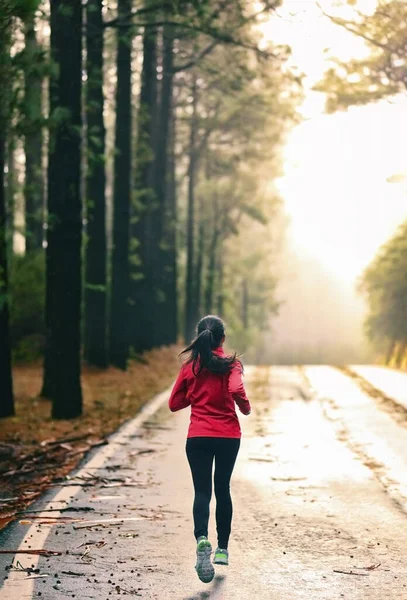 Atleta correndo na estrada de manhã ao nascer do sol treinamento para a maratona e fitness. Mulher saudável estilo de vida ativo exercitando ao ar livre — Fotografia de Stock