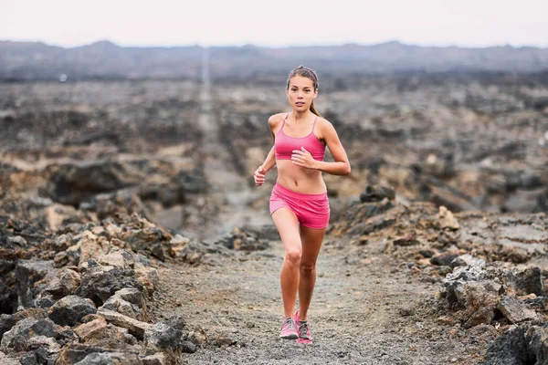 トレイルラン運動トレーニングは、ハワイの火山岩の道でトライアスロンレースを実行しているアジアのランナーの女性に適しています。スポーツフィットネスアスリートフルボディは、スポーツ服やランニングシューズを着て — ストック写真