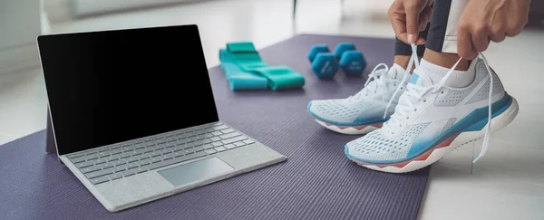 Online-Fitness-Kurs zu Hause Banner. Frau bereitet sich auf Hiit-Workout mit Laptop-Bildschirm zum Streamen vor. Schnürsenkel binden — Stockfoto