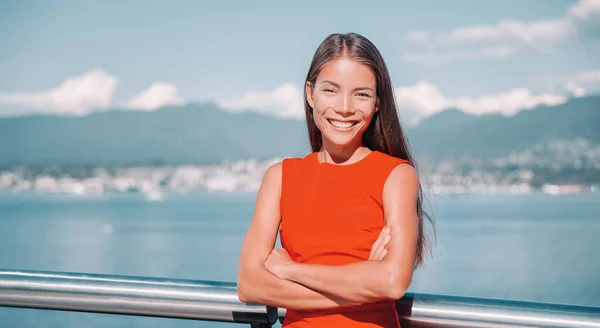 Mujer de negocios asiática confiada mujer de negocios multirracial retrato sonriendo con los brazos cruzados en la parte superior roja afuera en Vancouver, Canadá —  Fotos de Stock