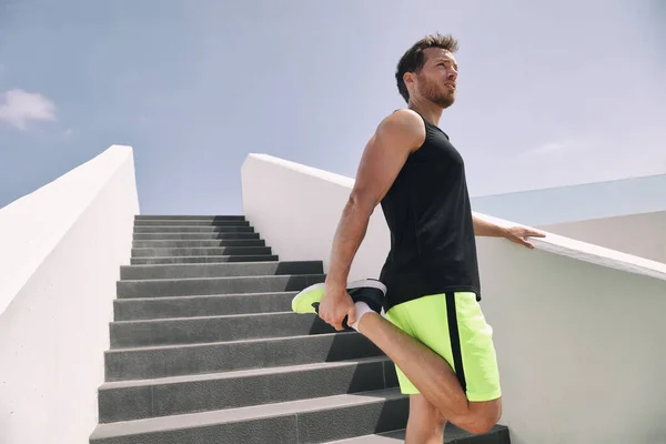 Fitness άνθρωπος δρομέας ετοιμάζεται να τρέξει τέντωμα πόδια ζεσταθεί quad τέντωμα άσκηση στην εξωτερική σκάλα cardio HIIT προπόνηση — Φωτογραφία Αρχείου