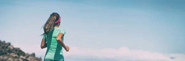 Meisje runner hardlopen op pad lopen outdoor zomer landschap in bergen header panoramisch van blauwe hemel achtergrond. Vrouwelijke atleet vrouw training cardio buiten het dragen van hoofdband en paardenstaart — Stockfoto