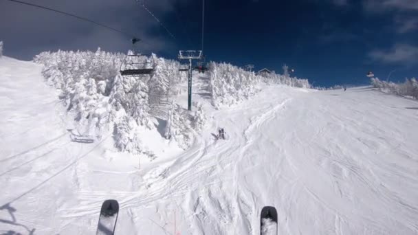 Зимние лыжные каникулы. ПОВ с лыжами в лифте и гондолой. Катание на лыжах по снежным склонам в горах, Люди веселятся в снежный день - Зимние виды спорта и мероприятия на открытом воздухе — стоковое видео