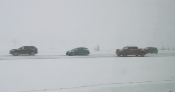 Tempête de neige avec mauvaise visibilité sur l'autoroute avec routes glissantes, circulation. Voitures conduisant dans la tempête de neige en hiver — Video