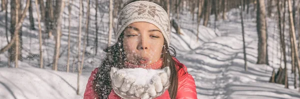 冬天，亚洲的年轻女子在雪地上吹雪，在大自然的森林里玩耍。快乐女孩的横幅全景，穿着冷天饰品 — 图库照片