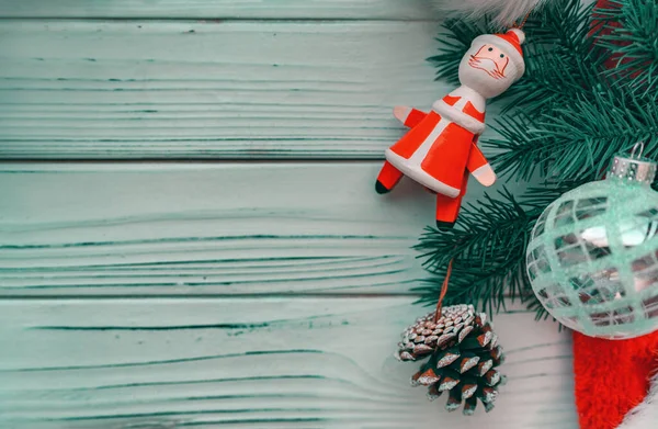 Weihnachten Holz Hintergrund mit Kiefer dekoriert mit Miniatur-Weihnachtsmann Holz Spielzeug, Glaskugel Ornament und Kegel — Stockfoto