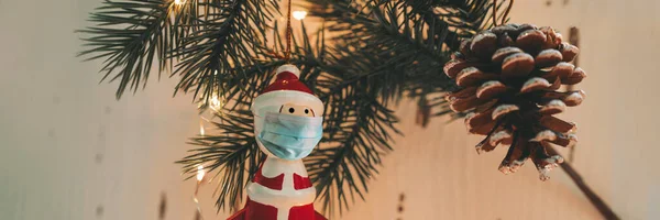 Weihnachtsbaumschmuck mit chirurgischer Gesichtsmaske zur Coronavirus-Prävention während des Familienfestes. Banner der sozialen Distanzierung — Stockfoto