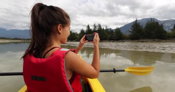 Kajak. Kobieta korzystająca z telefonu robi zdjęcia kajakarstwo w Squamish Estuary otoczony górami relaks korzystających spokój. Ludzie żyjący zdrowym życiem na świeżym powietrzu w Kolumbia Brytyjska, Kanada. — Wideo stockowe
