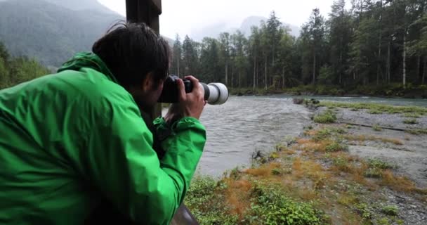 灰熊的生活。野生动物摄影师游客拍摄棕熊在大自然中吃鲑鱼的照片。加拿大布特湾和坎贝尔河附近不列颠哥伦比亚省沿海的河流景观中的熊 — 图库视频影像