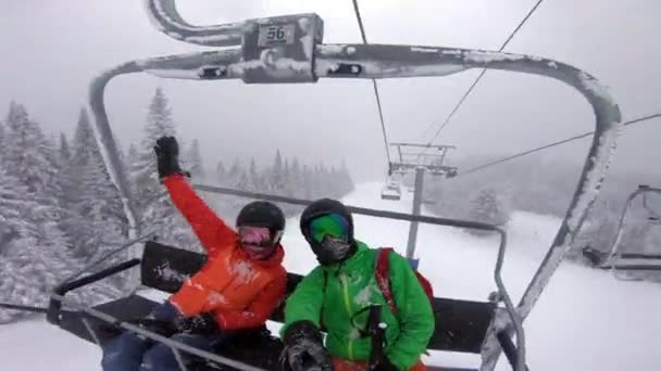 스키 여행 - 스키 리프트에 있는 사람들 이 셀피 비디오를 찍는 모습. 겨울 휴가는 겨울을 의미 한다. 산비탈에서 스키를 타고 눈내리는 날에는 야외 스포츠 활동을 즐기는 부부들 — 비디오