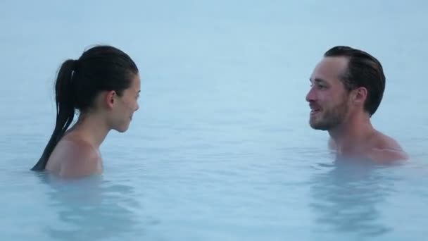 Пара спа-салонов зимой. Молодая женщина и мужчина наслаждаются романтическим горячим бассейном — стоковое видео