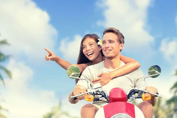 Pareja que viaja en scooter durante las vacaciones de verano en Europa. Jóvenes turistas cabalgando durante el viaje por carretera, chica señalando hacia otro lado. Concepto de vacaciones. — Foto de Stock