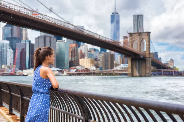 ニューヨークニューヨーク夏の旅行観光客の女性は、米国の休暇中に幸せなライフスタイルの歩行生活を送るブルックリン公園からマンハッタンのスカイラインの景色を楽しんでいます。20代の女性アジア人観光客. — ストック写真