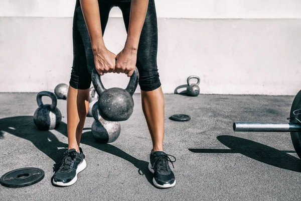 ケトルベルウェイトリフティング選手の女性は屋外フィットネスジムで体重を持ち上げる。体の下の足と足の強さのトレーニングの足の近くに、接着剤と自由重量を持ち上げる背部. — ストック写真