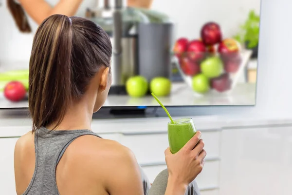 Émission de télévision regarder les femmes sur la saine alimentation perte de poids et boire un smoothie vert. Fille devant la télévision en ligne sur la nutrition. Fille assise à la maison en apprendre davantage sur les légumes et les fruits. — Photo